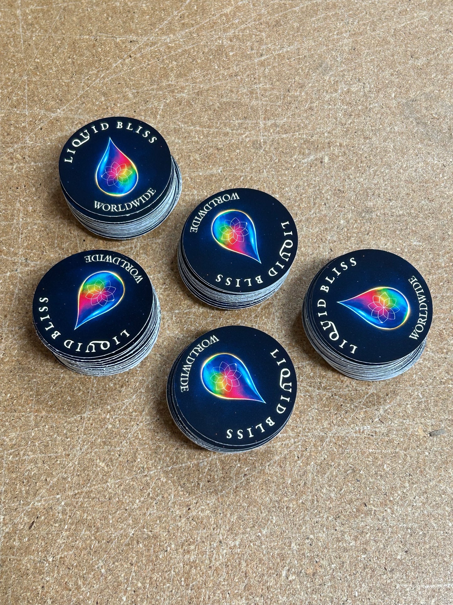 Stacks of 'Liquid Bliss' product containers on a textured surface