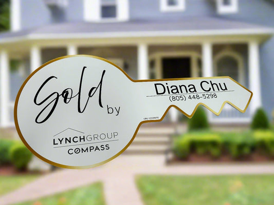 A custom-shaped, white-colored ceramic key prop sign with the words ' Sold by' and a placeholder for an agent name, against a blue background with a 'As low as $33.75/ea' banner.