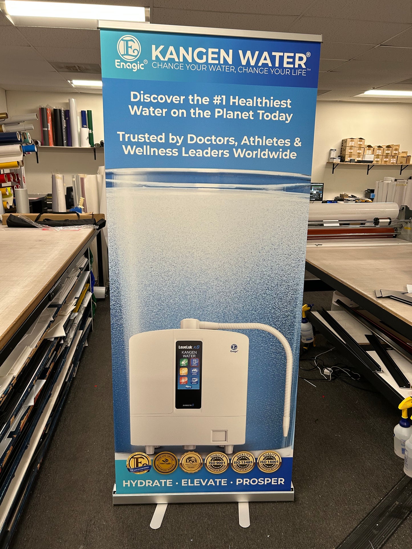 Kangen Water machine display with branding and product features on a stand.