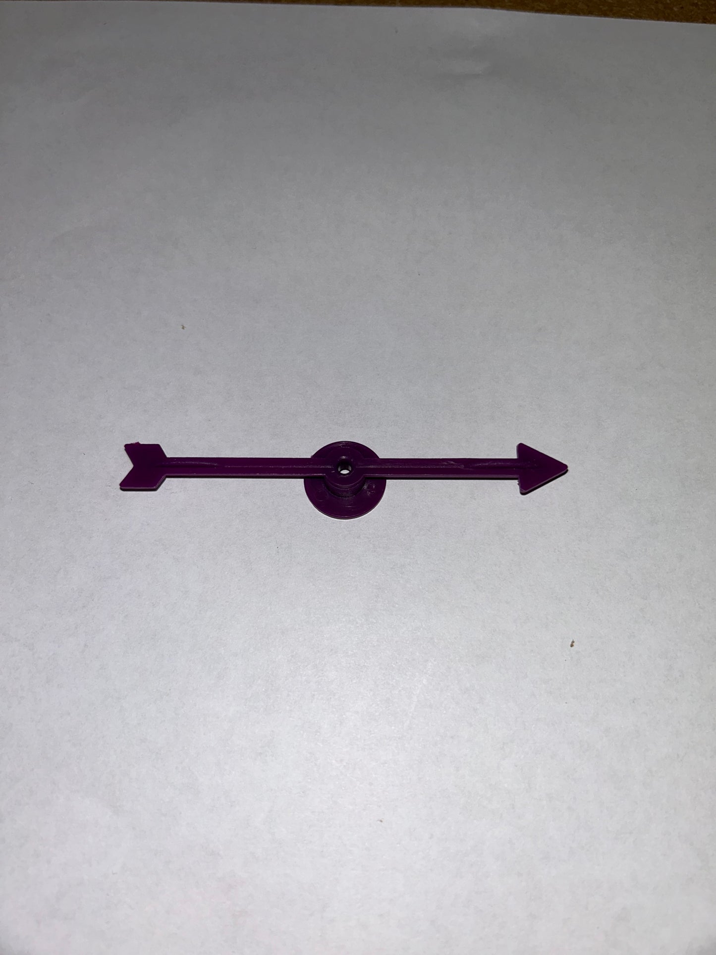 A collection of colorful plastic arrow spinners with a circular base, designed for use in board games and tabletop RPGs.