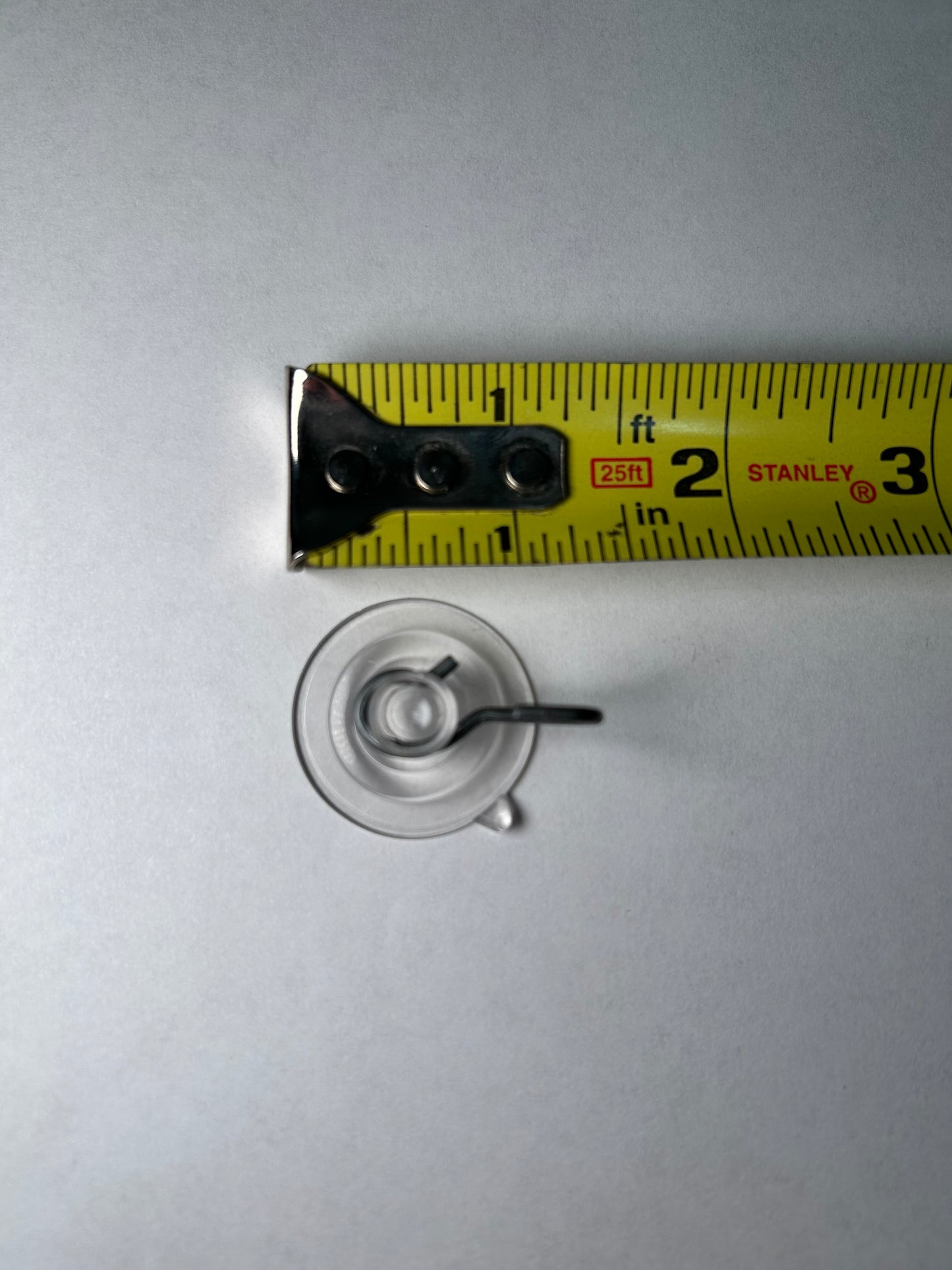 A suction cup with a metal clip attached, designed for sign post mounting.
