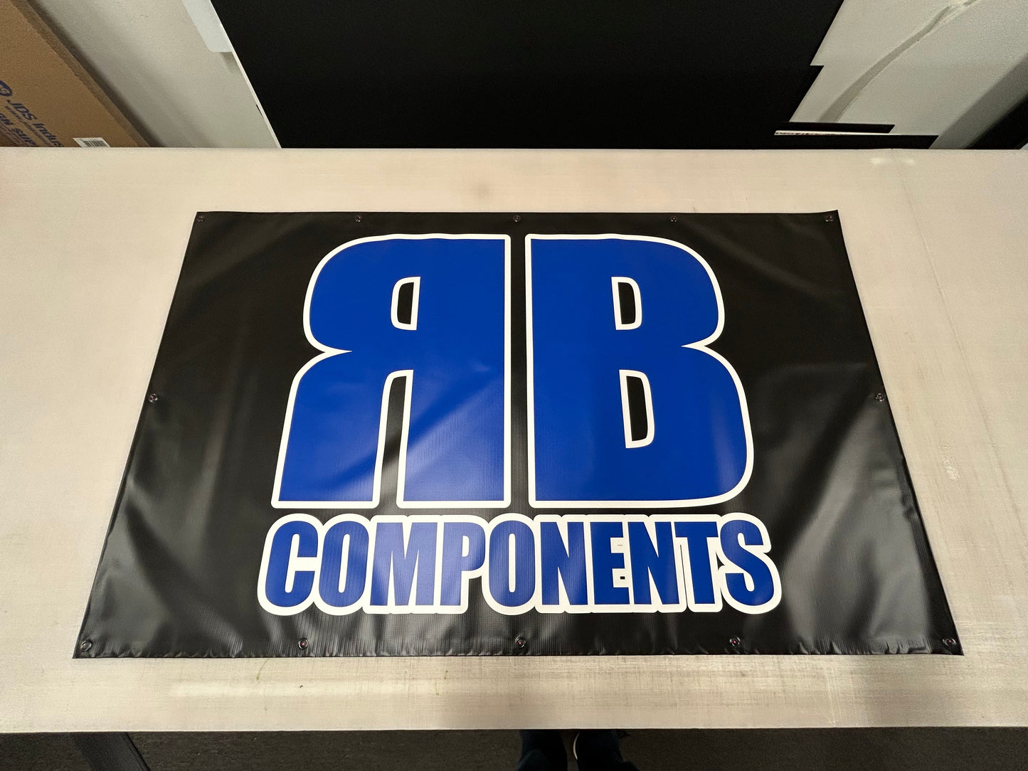 Black banner with blue and white 'YB Components' logo on a light-colored surface.