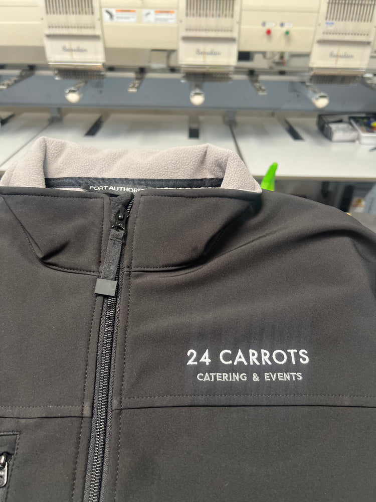 Black jacket with '24 Carrots Catering & Events' branding on a blurred background