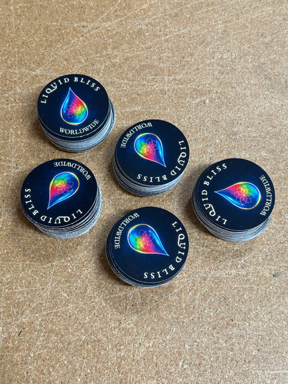 Stacks of 'Liquid Bliss' product containers on a textured surface