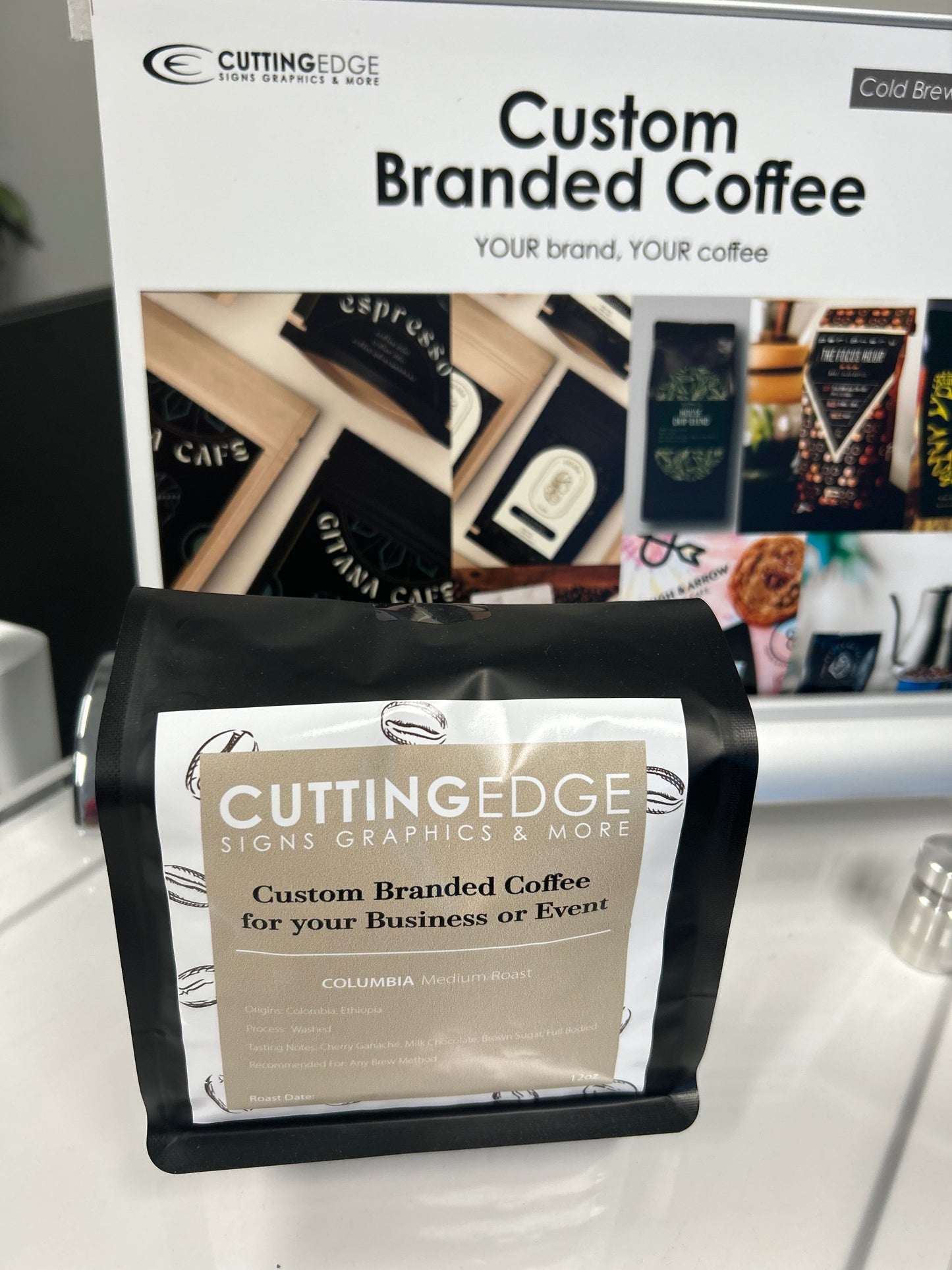Custom branded coffee packaging with 'Cutting Edge' branding on a stand.