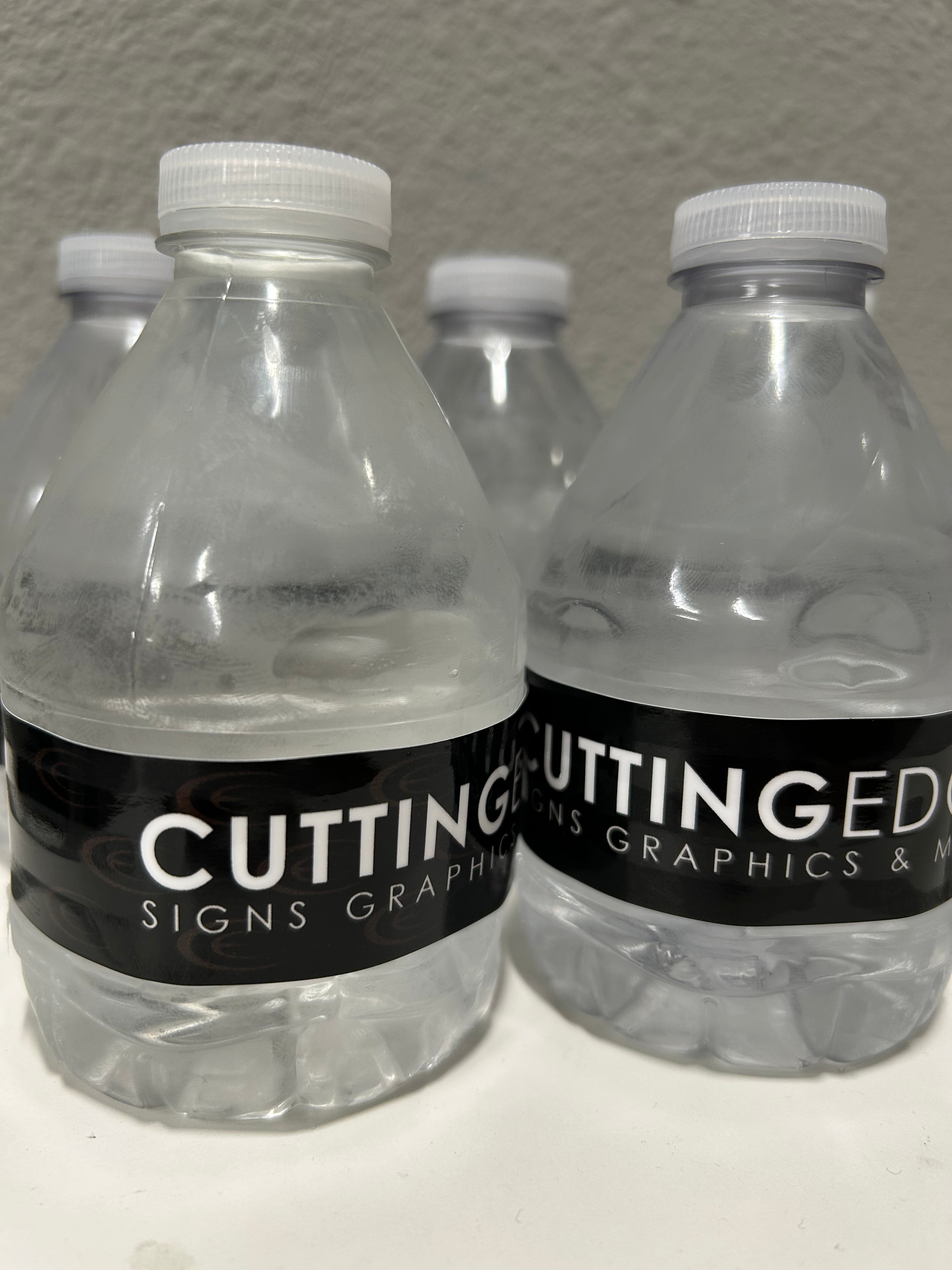 Three clear plastic bottles with black labels on a gray surface