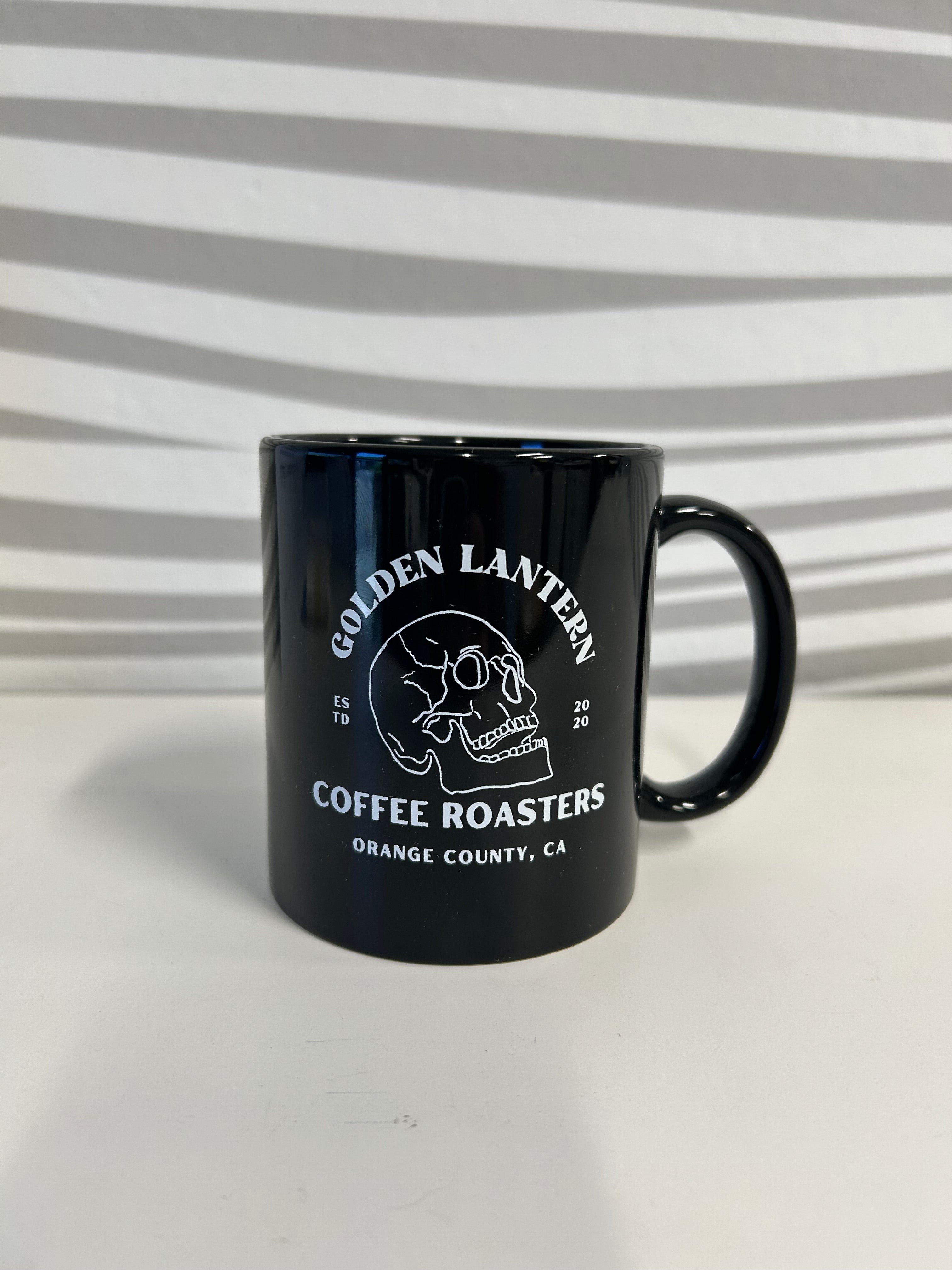 Black mug with a logo and text on a white background