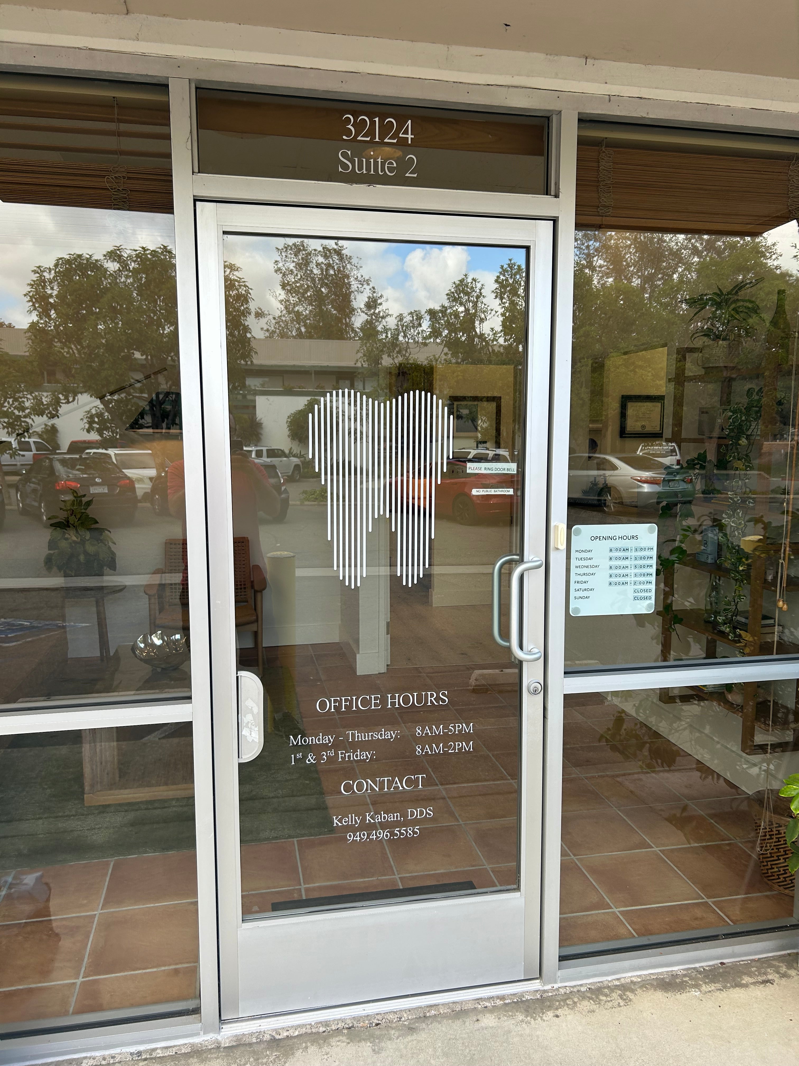 Glass door with reflections of trees and building interior