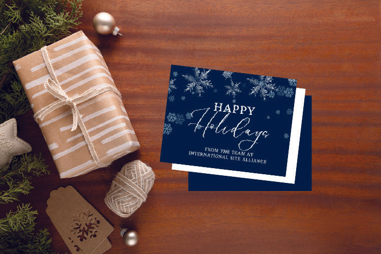 A holiday card placed under a Christmas tree, surrounded by festive decorations and lights. Perfect for seasonal greetings, this image captures the warmth and spirit of the holidays, showcasing a personalized card ready to spread cheer and joy.