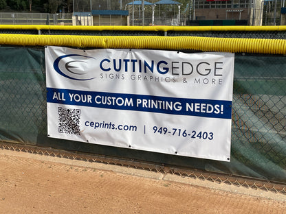 Cutting Edge Signs Graphics & More banner on a chain-link fence with a sports field background.