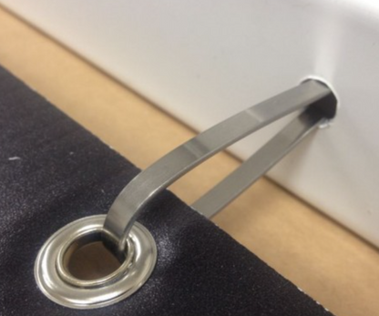 A close-up image of a silver U-shaped sign clip attached to a sign post with a hole, set against a blurred background.