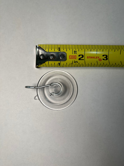 A suction cup with a metal clip attached, designed for sign post mounting.