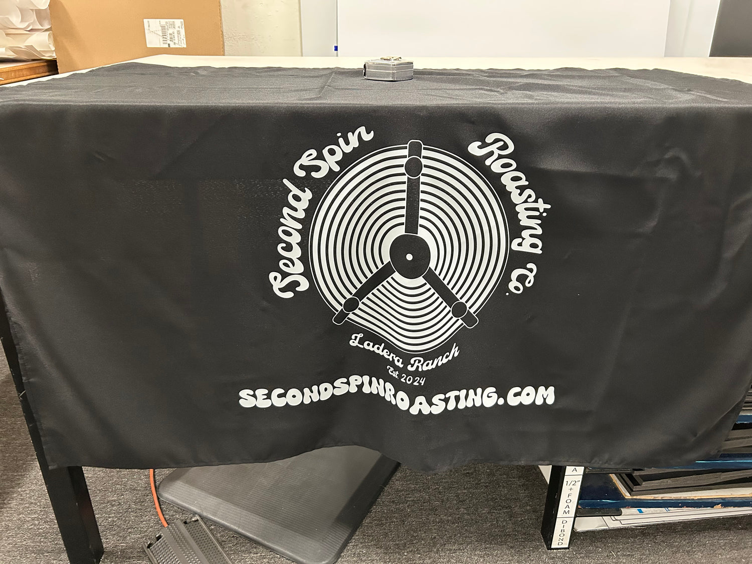 Black tablecloth with 'Second Spin Roasting' logo on a table