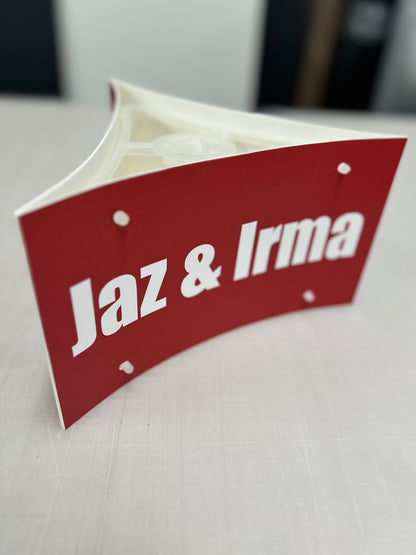 Red sign with 'Jaz & Irma' text on a white surface