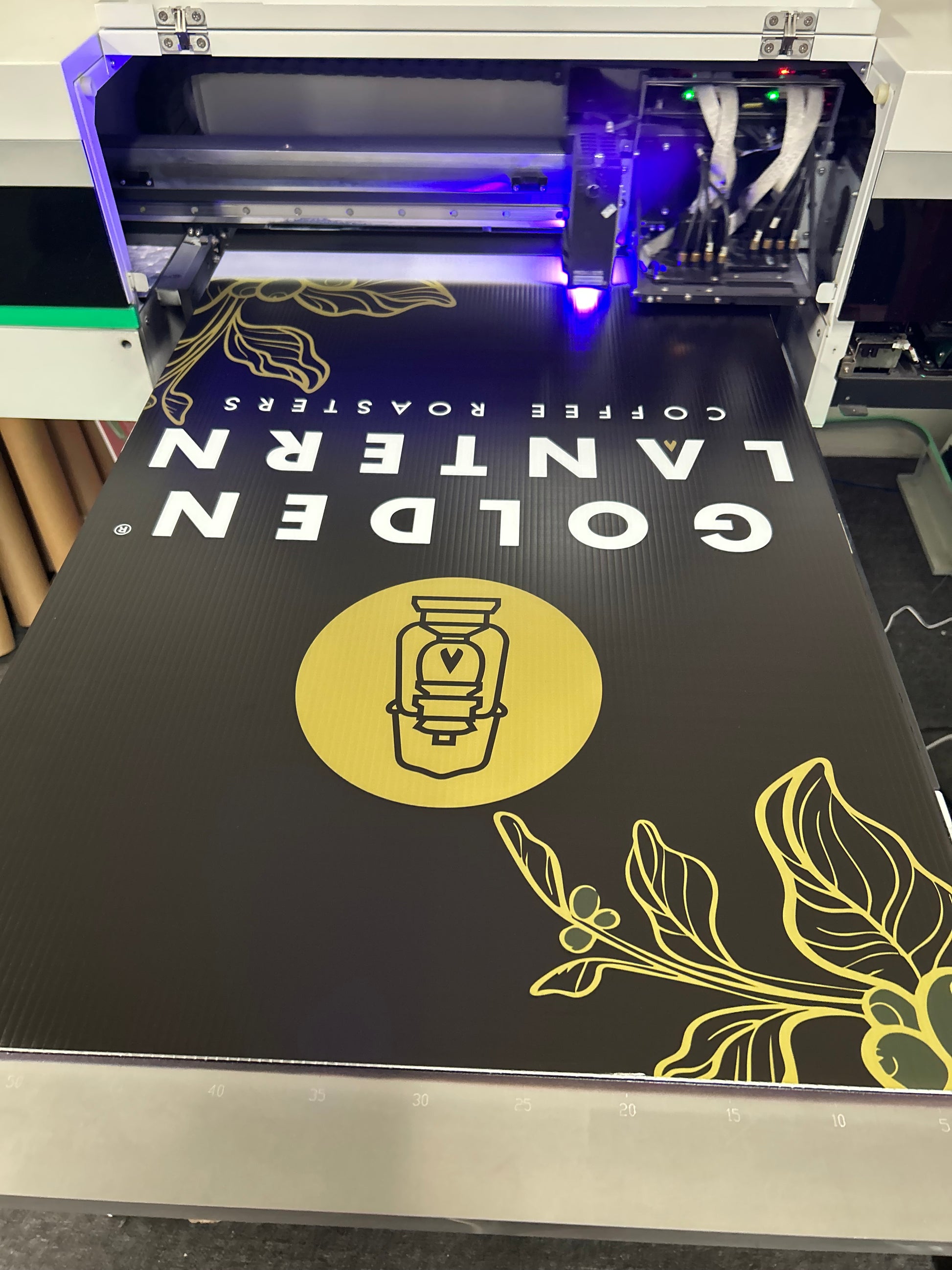 3D printer with Golden Lantern Coffee Roasters branding on a black background