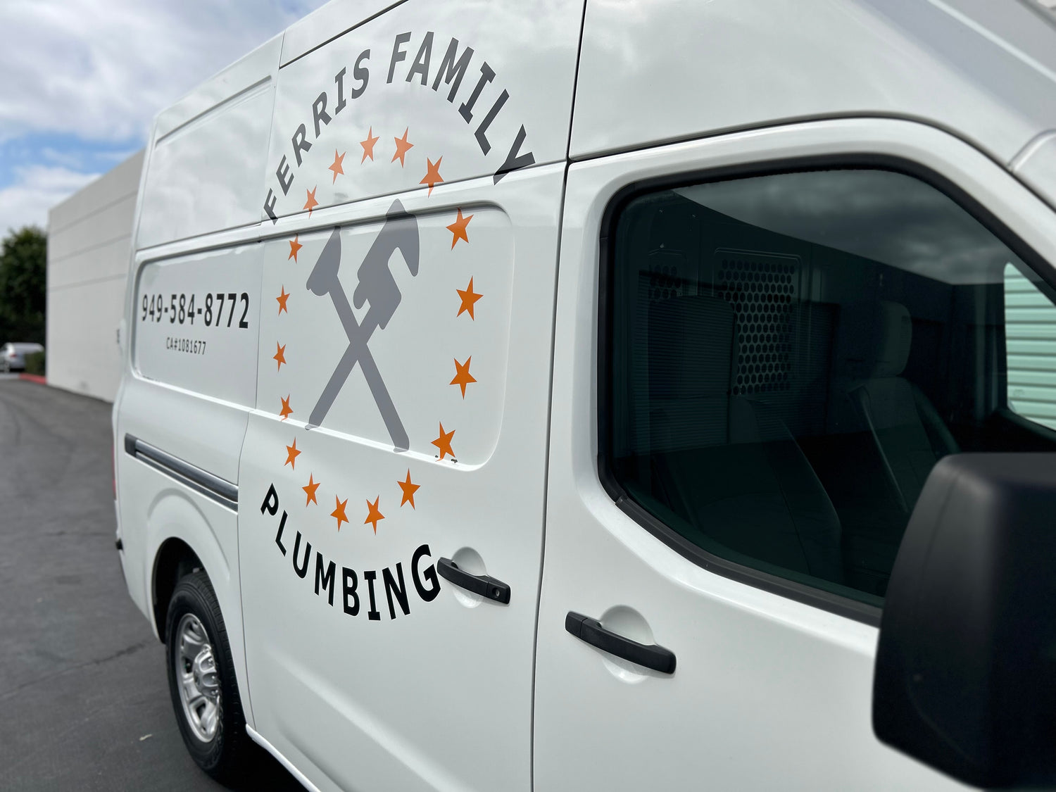 White van with 'Ferris Family Plumbing' logo and contact information on a cloudy day.