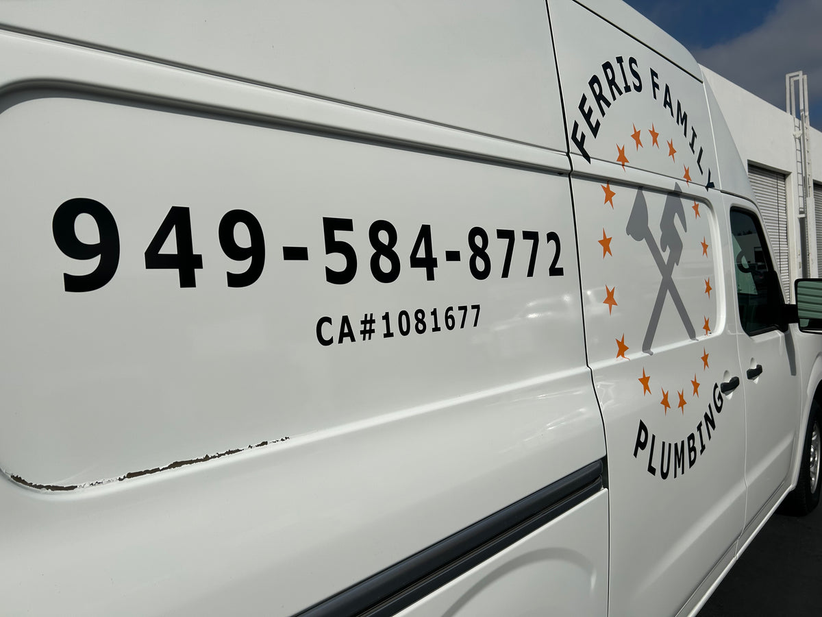 White van with Ferris Family Plumbing logo and contact information on a clear day.