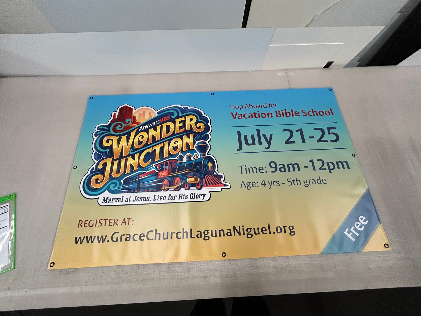 Vacation Bible School sign for Wonder Junction at Grace Church Laguna Niguel on a metal surface.