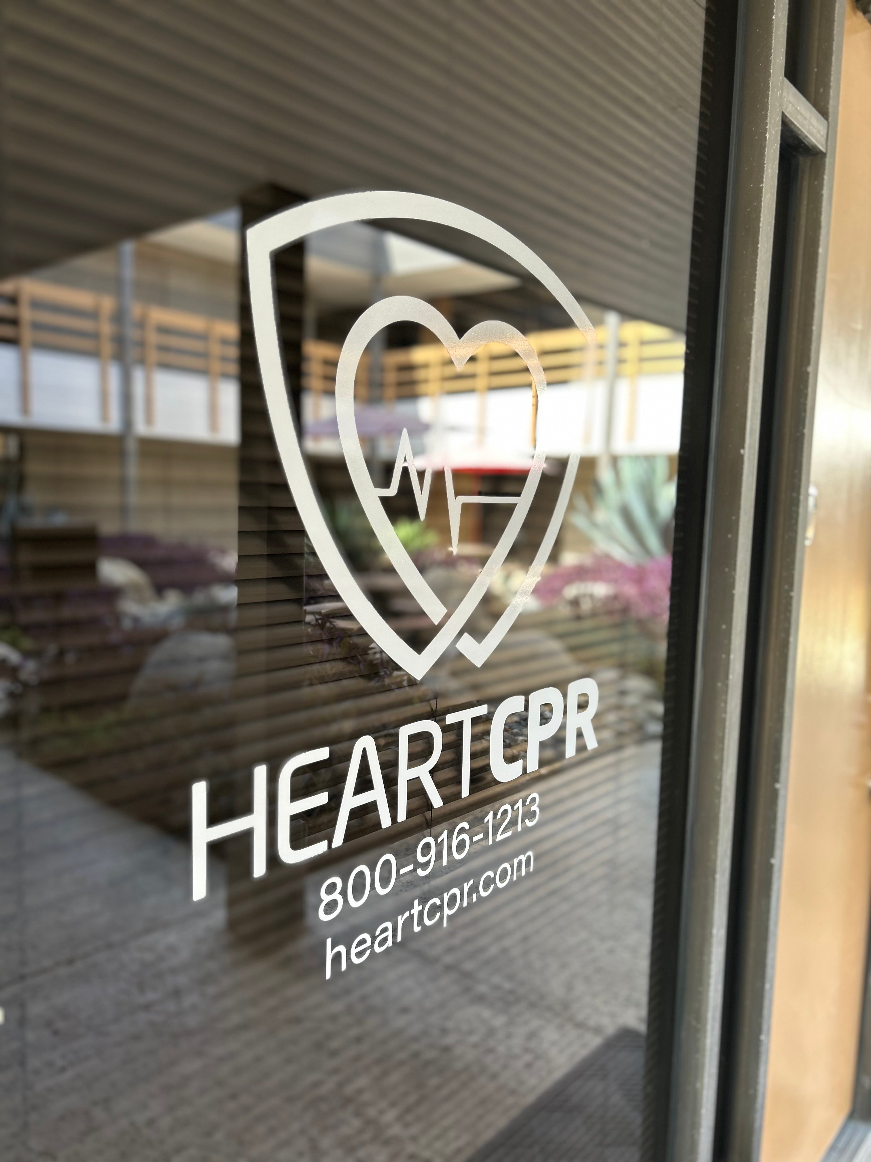 HEARTCPR logo on a glass door with contact information